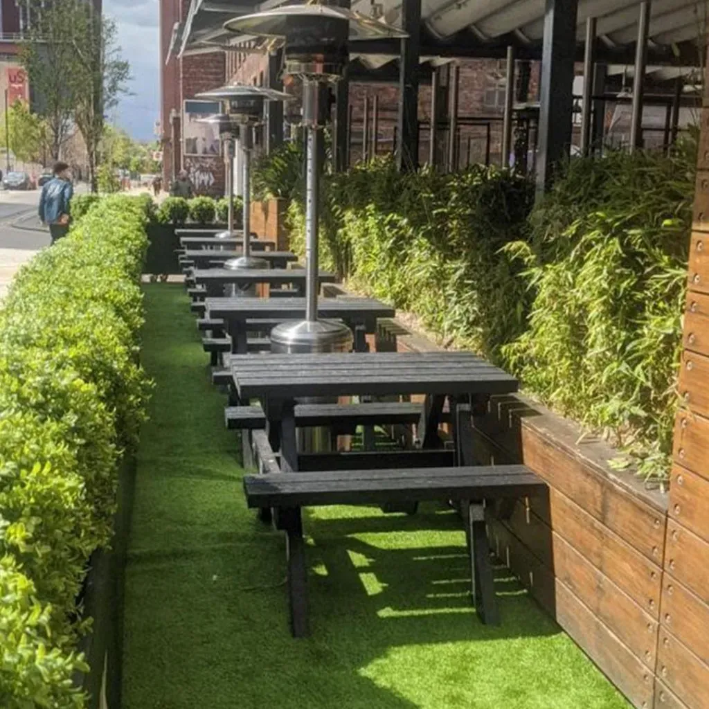 A row of Recycled Black Plastic Picnic Table outside a cafe