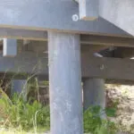 Grey Recycled Plastic Piles supporting a jetty on land.