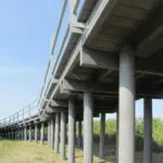 Grey Recycled Plastic Piles supporting a raised walkway over land.