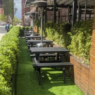 A row of Recycled Black Plastic Picnic Table outside a cafe